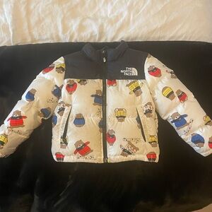 The North Face White Puffer Jacket with Black Yoke and Multi-Color Bear Print